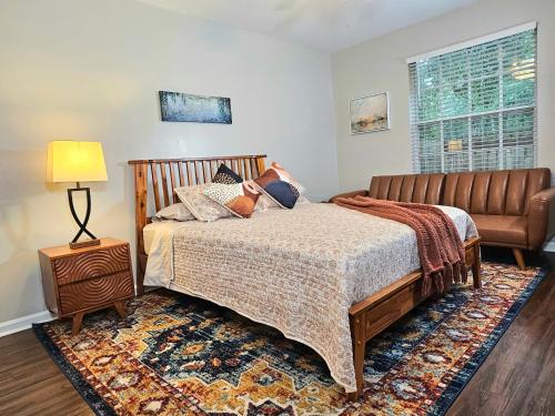a bedroom with a bed and a couch at Pristine Elegance meets Chic Charm! in Tallahassee