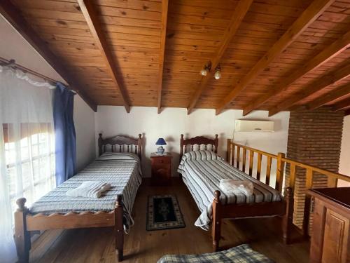 two beds in a room with wooden ceilings at Bungalows Solares de Colón in Colón