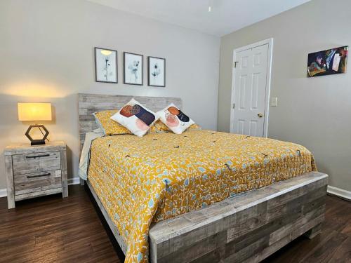 a bedroom with a bed and a night stand with a lamp at Pristine Elegance meets Chic Charm! in Tallahassee