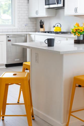 a kitchen with a white counter and yellow stools at Pleasant Valley Resort in Arcadia
