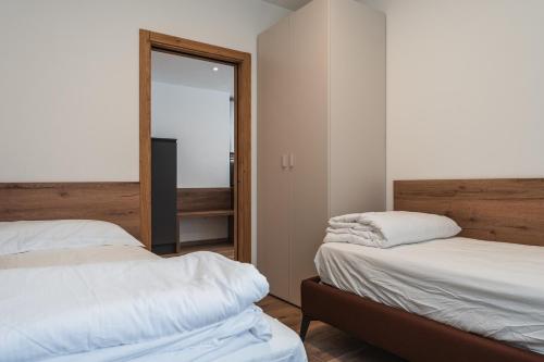a bedroom with two beds and a mirror at Casa Stefania 2 in Pieve Di Ledro