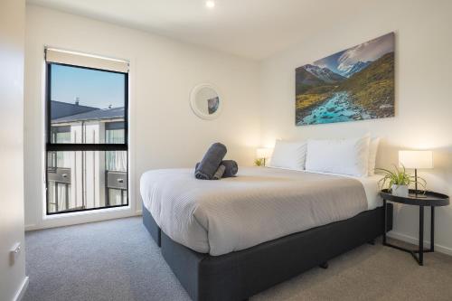 Albert TownにあるNew & Stylish Townhouse - Explore Wanaka, Ski Cardronaの大きなベッドと大きな窓のある寝室