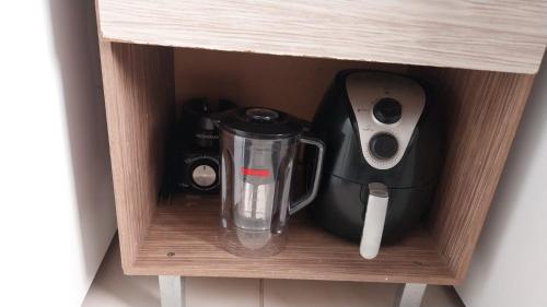 a coffee maker and a blender sitting on a shelf at La Bella casa in Catanduva