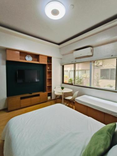 バギオにあるCEDAR PEAK by AWESOME STAY in Baguioの大きなベッドと薄型テレビのある寝室