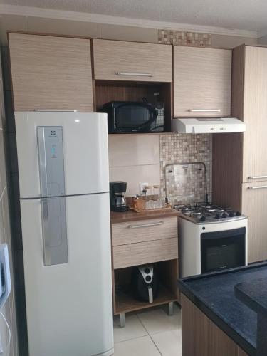 a kitchen with a white refrigerator and a stove at La Bella casa in Catanduva