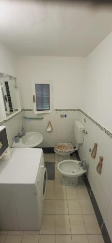 a white bathroom with a toilet and a sink at La Casetta in Marina di Massa
