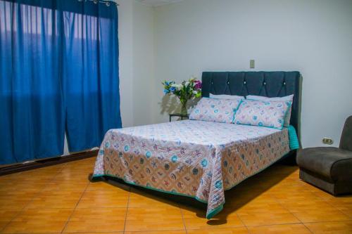 a bedroom with a bed with a blue curtain at Cata Bed Breakfast Pet-friendly in San José