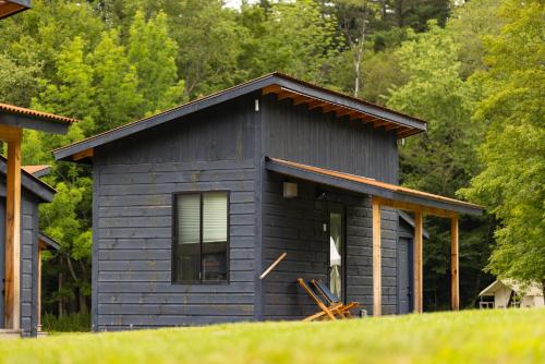 a small blue house with a window and trees at Madbush Falls in Waitsfield