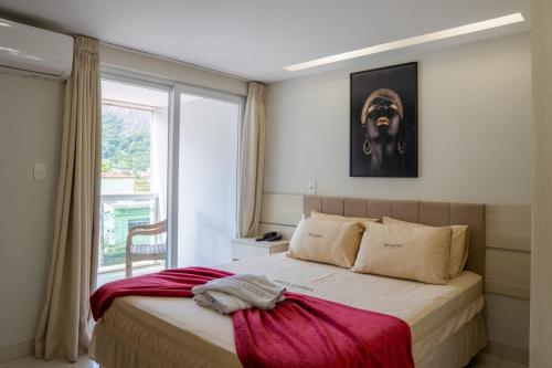 a bedroom with a large bed and a window at Ibiza Barra Hotel in Rio de Janeiro