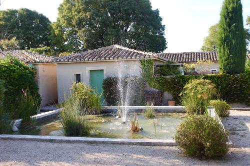 una casa con una fuente en un jardín en Mazet, the gardens of Luciens, en Saint-Rémy-de-Provence