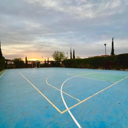 a blue tennis court with the sunset in the background at Waky Marrakech Villa in El Rhechat