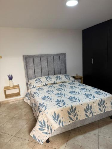 a bedroom with a bed with a blue and white bedspread at Hermoso apartamento en guayabal in Medellín