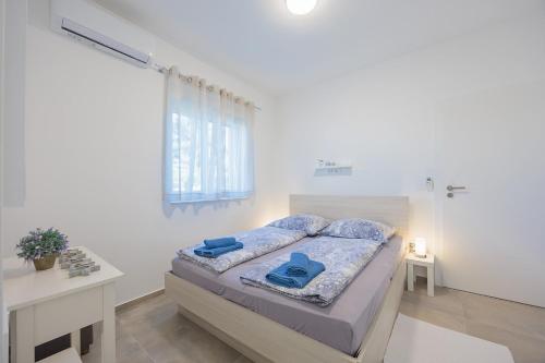 a bedroom with a bed with blue pillows on it at VIRCATION Apartments in Vir