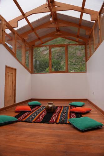 a room with a large table with pillows on it at Casa de campo Asikuy House in Urubamba