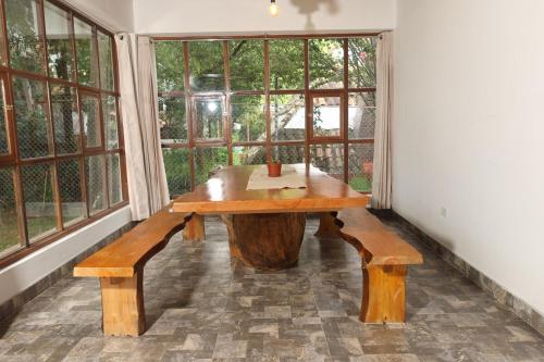 a wooden bench in a room with windows at Casa de campo Asikuy House in Urubamba