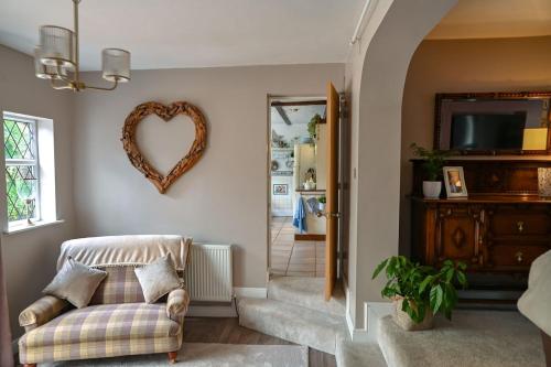 ein Wohnzimmer mit einem herzförmigen Spiegel an der Wand in der Unterkunft Beautiful apartment at field view cottage in Eccleston