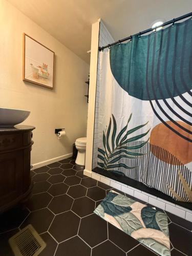 a bathroom with a shower curtain and a toilet at Tampa Jungalow- Pool Oasis in Tampa