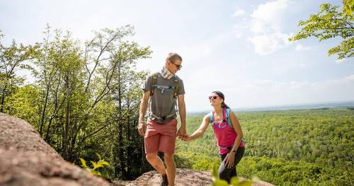 a man and woman holding hands while standing on a rock at Gorgeous apartment across from La Crosse Center in La Crosse