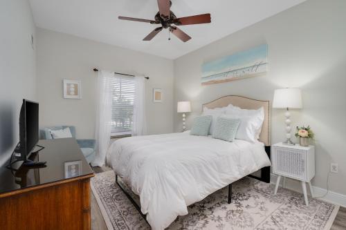 a white bedroom with a bed and a ceiling fan at 3br L Pool Family & Corporate Travel Sleeps 6 in Palm Coast