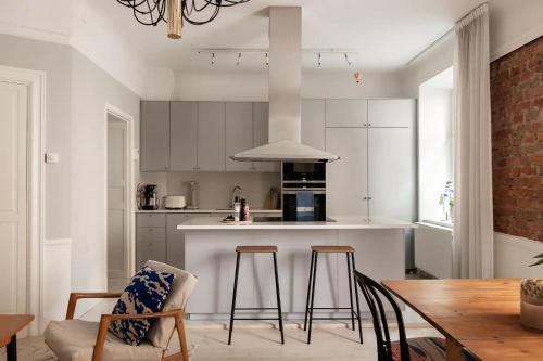 a kitchen with white cabinets and a table and chairs at Modern och ljus lägenhet 