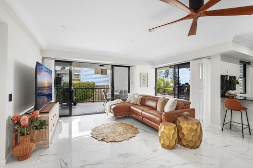 a living room with a couch and a table at Oceanfront Luxe 2BR in Bargara