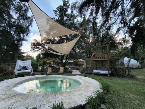 a hammock hanging over a small pool in a yard at Paraje Real Malinalco in San Martín