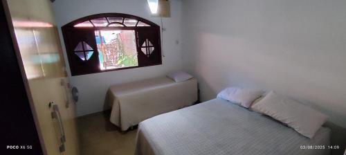 a small bedroom with a bed and a window at Casa temporada Monsuaba in Angra dos Reis
