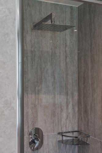 a shower with a glass door and a shower head at Casa Stefania 3 in Pieve Di Ledro