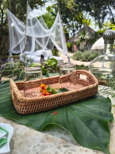 a picnic basket with glasses and flowers on a table at Paraje Real Malinalco in San Martín