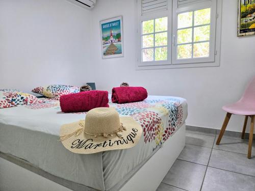 a bedroom with a bed with a hat on it at Villa Carpe Diem - Piscine - 9 pers - 4 Chambres in Les Trois-Îlets