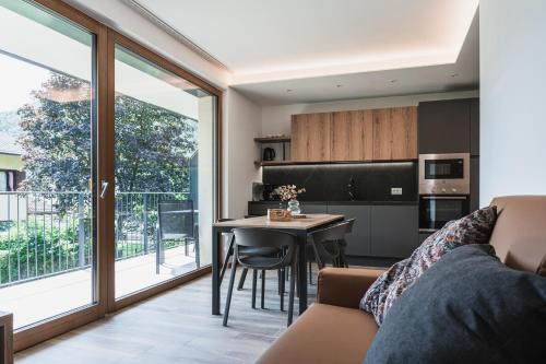 a living room with a couch and a kitchen with a table at Casa Stefania 3 in Pieve Di Ledro