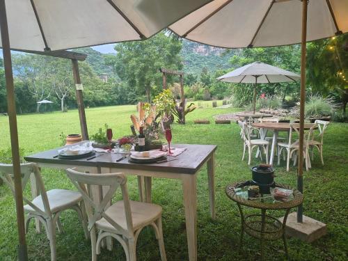 a table and chairs with umbrellas in a yard at Paraje Real Malinalco in San Martín