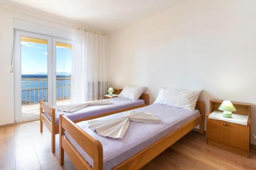 two beds in a bedroom with a view of the ocean at Apartments with parking space Dramalj, Crikvenica - 5592 in Dramalj