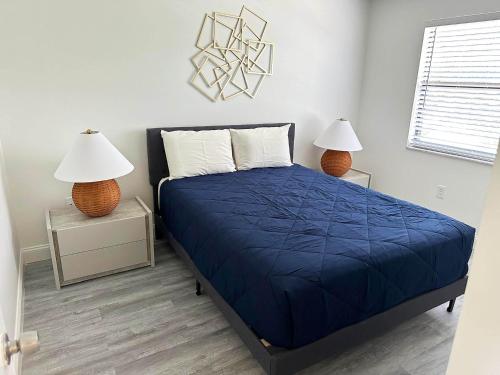 a bedroom with a bed with a blue comforter and two lamps at Family vacation Villa in Fantasy World Resort - Minutes from Disney in Kissimmee