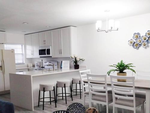 a kitchen with white cabinets and a table and chairs at Family vacation Villa in Fantasy World Resort - Minutes from Disney in Kissimmee
