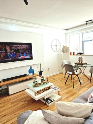 a living room with a tv on a wall at Luxe-Design Imperio II- Petit Déjeuner 5min de la Mer in Praia