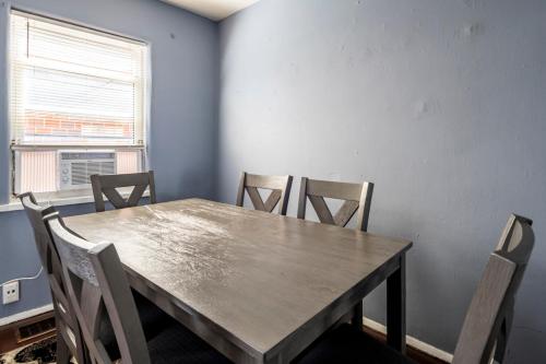 a dining room with a wooden table and chairs at Cozy 2BR Retreat with Workspace - Washer and Dryer in Kettering