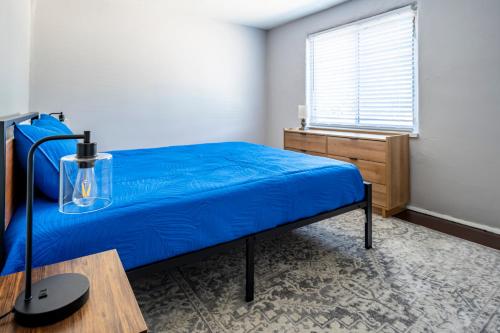 a bedroom with a blue bed and a window at Cozy 2BR Retreat with Workspace - Washer and Dryer in Kettering