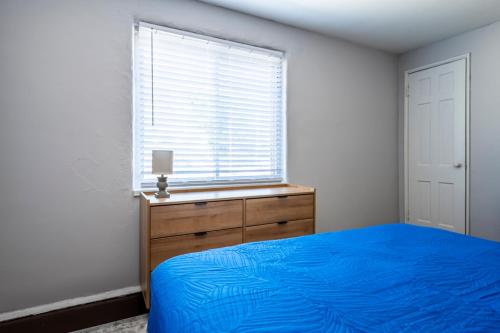 a bedroom with a blue bed and a window at Cozy 2BR Retreat with Workspace - Washer and Dryer in Kettering