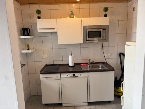 a small kitchen with a sink and a microwave at Steffies Apartment two in Idstein