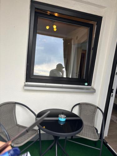 a table and two chairs in front of a mirror at Steffies Apartment two in Idstein