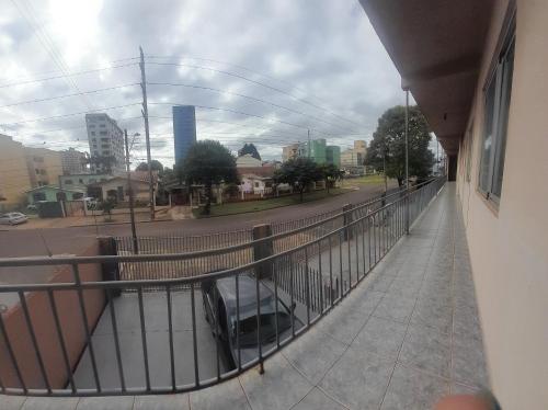 a balcony of a building with a car on a street at Central 2 quartos WIFI Próximo shopping JL e terminal rodoviário in Cascavel