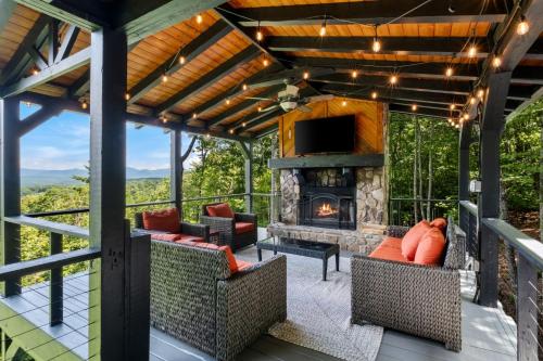 an outdoor living room with a fireplace and a tv at Top of the Mountain Breathtaking Views Hot Tub in Blue Ridge