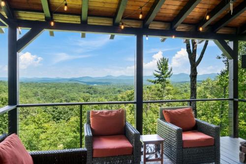a screened in porch with chairs and a view of the mountains at Top of the Mountain Breathtaking Views Hot Tub in Blue Ridge