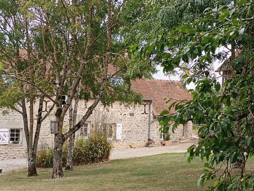 une maison en briques avec des arbres devant elle dans l'établissement Charmant gîte en Normandie avec jardin et activités à sensations - FR-1-410-300, à Arçonnay