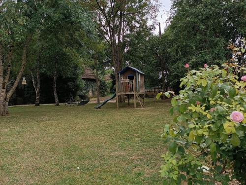 un parc avec une aire de jeux avec une structure de jeu dans l'établissement Charmant gîte en Normandie avec jardin et activités à sensations - FR-1-410-300, à Arçonnay
