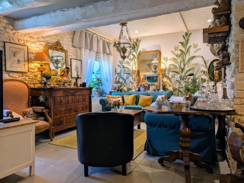 a living room with a table and blue chairs at Maison d'hôtes rénovée avec table d'hôte dans la campagne Altiligérienne - FR-1-582-522 in Saint-Victor-sur-Arlanc