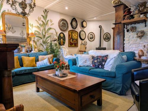 a living room with blue couches and a table at Maison d'hôtes rénovée avec table d'hôte dans la campagne Altiligérienne - FR-1-582-522 in Saint-Victor-sur-Arlanc