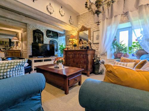 a living room with a couch and a tv at Maison d'hôtes rénovée avec table d'hôte dans la campagne Altiligérienne - FR-1-582-522 in Saint-Victor-sur-Arlanc