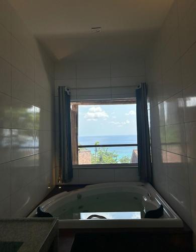 a bath tub in a bathroom with a window at Pousada do Nativo in Fernando de Noronha